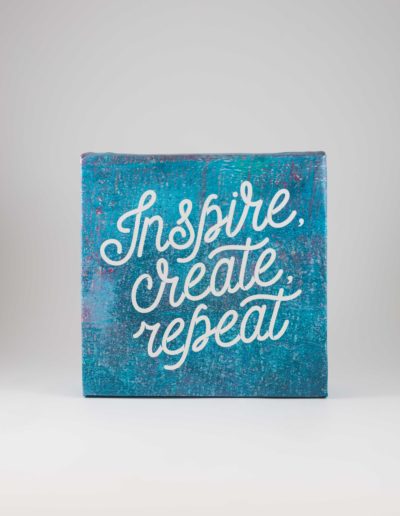 Square canvas with teal background and the words "Inspire, create, repeat" in a curly, fun cursive font